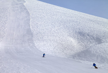 Ski slope and skiers at sun day