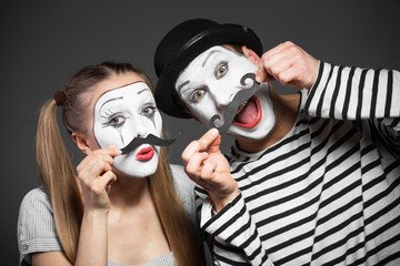 Couple of mimes with paper mustaches