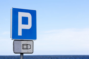 blue parking sign on a beach. balitc sea