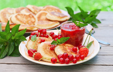 Pancakes with berries on a wooden background 