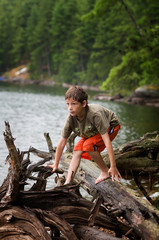 young boy exploring by a remote lake