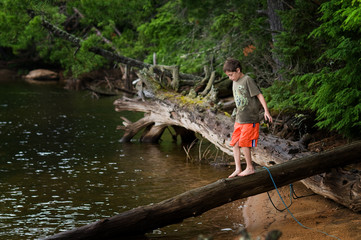 Fototapeta na wymiar young boy exploring by a remote lake