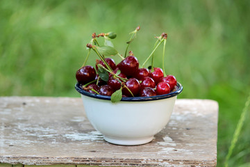 Ripe cherries in a vintage bowl on an old stool
