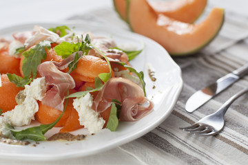 Melon salad with ham, arugola and mozzarella