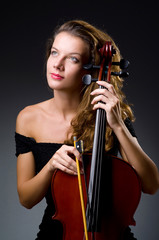 Female musical player against dark background © Elnur