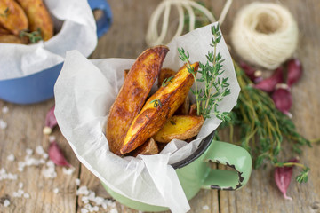 Potato wedges with thyme and garlic. The rustic style. Selective