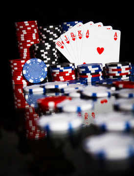 Poker chips and cards isolated on black background