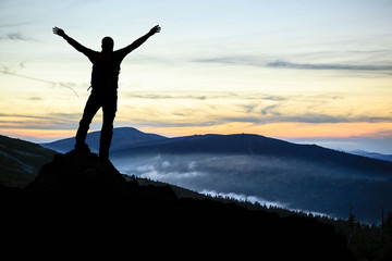 Man hiker successful with arms outstretched