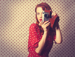 Portrait of redhead girl with retro camera
