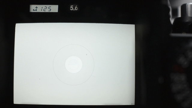 View of a waist-level viewfinder of an old SLR style film camera. Adjustments of the aperture and shutter. A couple of shutter fires.