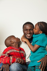 Son and daughter kissing her father