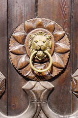 Fototapeta na wymiar Lion head, Door knocker on wooden door