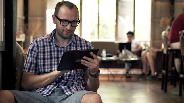Young man using tablet computer while sitting in cafe 

