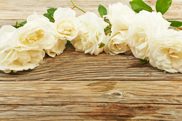 White roses on a wooden background