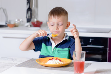 Young Boy Eating Plate of Cheese and Fruit