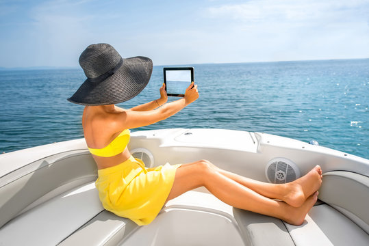 Woman relaxing with digital tablet on the yacht