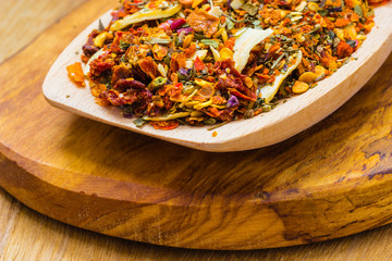 Colored spices for pasta mix on wooden spoon