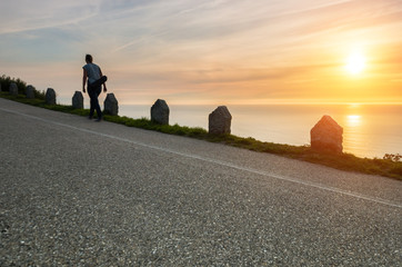 Mujer solitaria subiendo una cuesta al atardecer