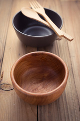 Wooden bowl and ceramic bowl with spoon and fork