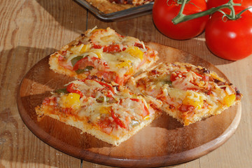 Pizza mit Paprika, Tomaten, Schinken, Zwiebeln, Käse