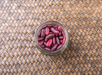 Red kidney beans in mason jar over wicker background