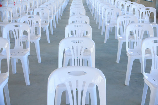 Stock Photo - Empty White Plastic Chairs For An Indoor Event.