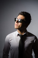 Young man in cool sunglasses isolated on gray