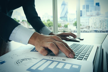 Close up of business man hand working on laptop computer on wood
