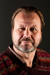 Portrait of a middle aged man with a beard wearing a sweater on