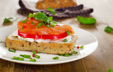 Sandwich with cereals bread and salmon on old wooden background.