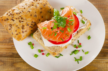 Sandwich with cereals bread and salmon on rustic wooden backgrou