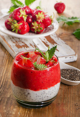 Chia seed pudding with strawberries on  a rustic wooden table.