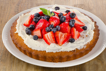 Strawberry and blueberry  cream cake with fresh mint