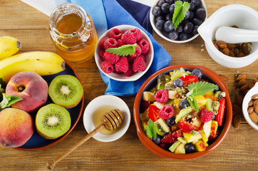 Healthy homemade fruit salad, fresh berries and fruits on   a wo