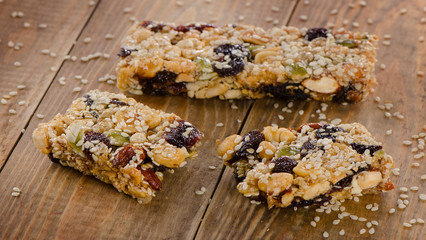 Healthy fruit and nut granola bars on a rustic wooden table.