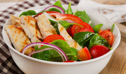 Salad with grilled chicken in  bowl.