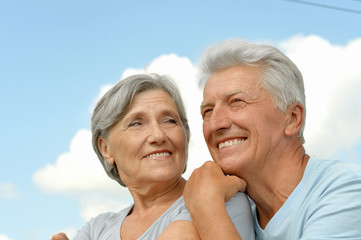 elderly couple posing against the sky