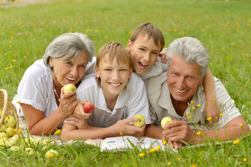 Family on  summer grass with apples