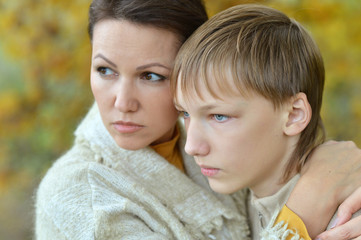 Sad mother with son in autumn park