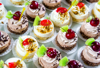 Delicious small fancy cakes decorated with fruit