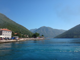 Морской залив с сине-голубой водой и побережье с горами