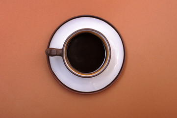 Obraz na płótnie Canvas Cup of coffee; a cup of coffee isolated on brown background; top view