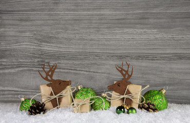 Holz Hintergrund in grau mit Geschenke, Elche und Dekoration in apfelgrün