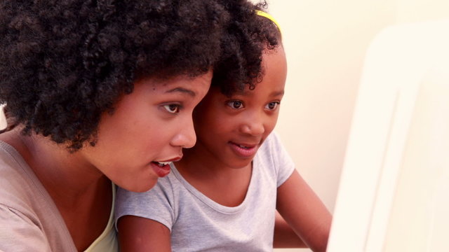 Child with her mother in the computer 