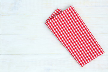 Red towel over wooden kitchen table. View from above with copy s