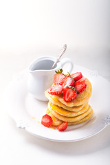 Stack of sweet pancakes with strawberry and honey.