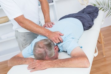 Obraz na płótnie Canvas Physiotherapist doing neck massage to his patient
