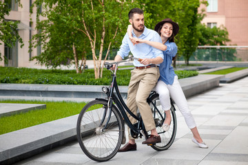 Young couple sitting on a bicycle 
