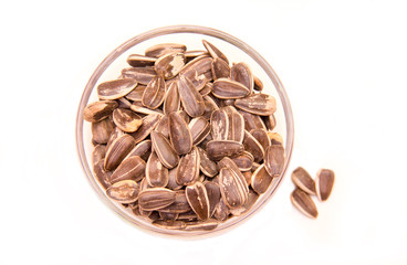 Sunflower seeds on a bowl on a white background seen from above