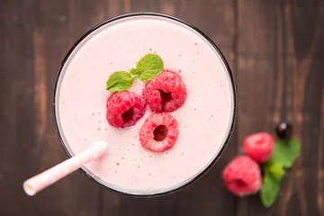 Photo sur Plexiglas Milk-shake Raspberry fruit smoothie with straw on wooden background.